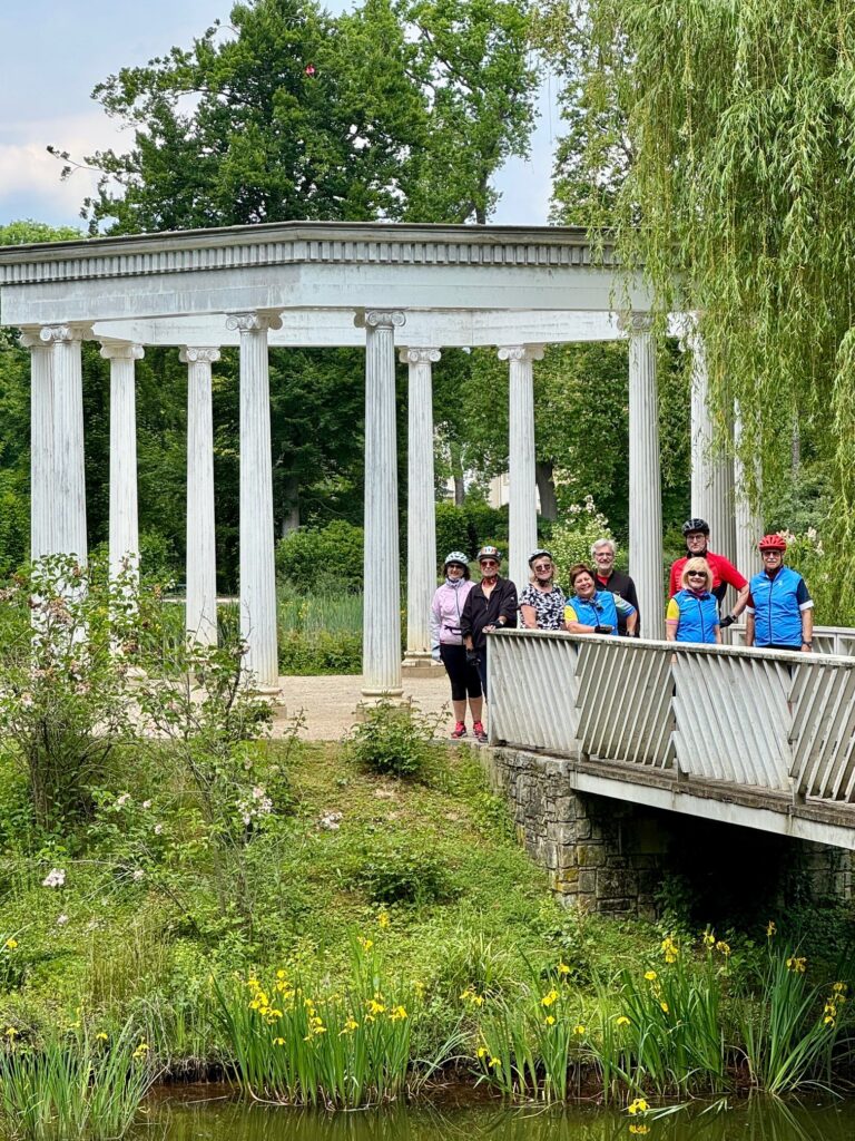 die Radlergruppe vor Gartentempel im kleinen Tannenwald,